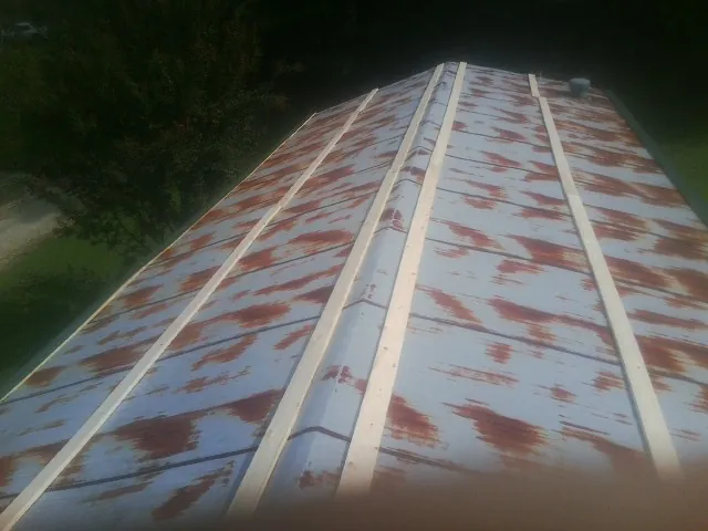 Rusted metal roof panels with new wood purlins before replacement — Storm Damage Roof Repair in Calhoun City by Roofing Brothers