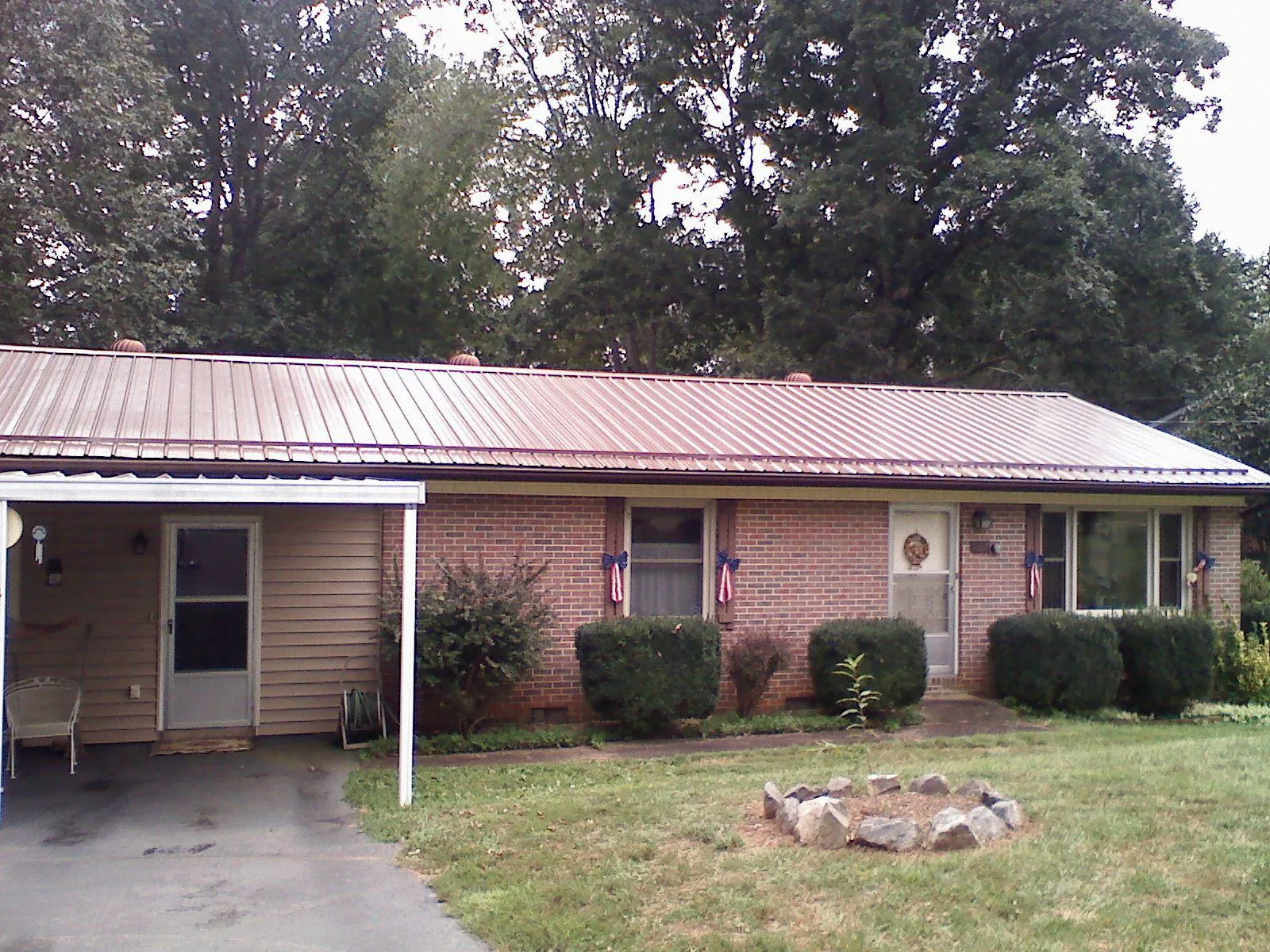 Bronze metal roof and carport on a brick ranch home — Roof Repair work by our crew in Calhoun City