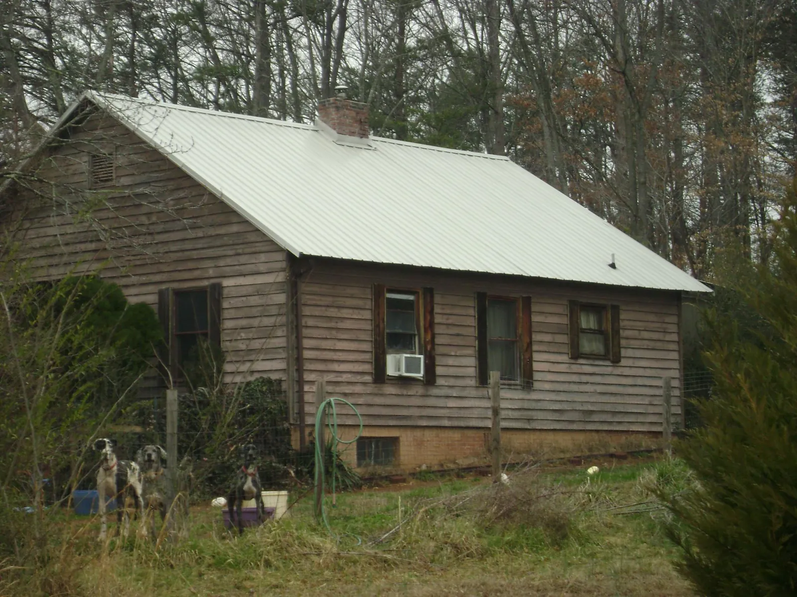 White metal roof on an old wood sided farmhouse, from a Metal Roof Installation job in Calhoun City